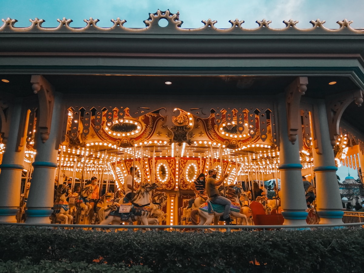 Theme park castle at dusk with colorful lights